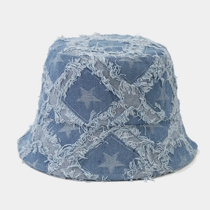 Detailed close-up of light blue denim bucket hat with distressed star patterns and raw edges
