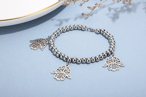 Detailed view of silver beads bracelet featuring delicate Hamsa Hand hollow pendants