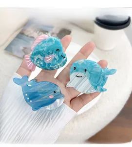 Three sea animal hair clips in blue acetate with marble texture and pearl accents