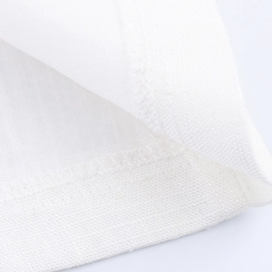 Detailed close-up of white breathable linen-like fabric texture and fine stitching on blazer
