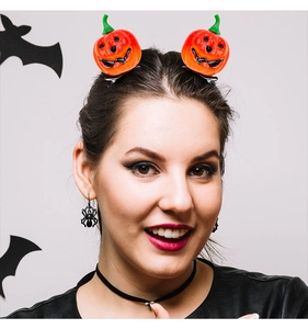 Close-up of cute pumpkin hair clips and black spider earrings for Halloween party outfits