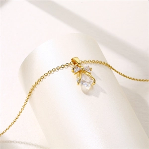 Golden bow pendant necklace with large square zircon stone on minimalist white stand