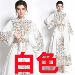 Détail de robe longue blanche à motif paisley avec manches cloche et ceinture imprimée