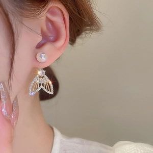 Vue macro de boucles d'oreilles queue de sirène avec perles et zircons sur un mannequin