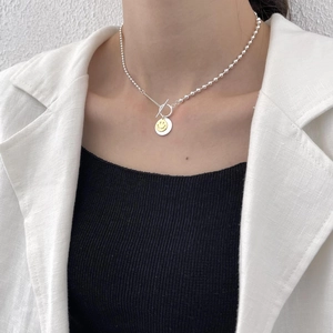 Silver smile pendant necklace with toggle clasp and beaded chain on female model