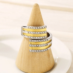 Détail macro d'une bague bicolore en acier avec sertissage de diamants sur support bois
