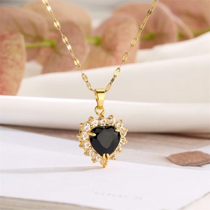 Detail of a black heart-shaped pendant with gold chain and white zircon accents