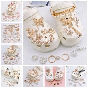 Detail of DIY shoe charms set with gold butterfly, pearl chain, and rhinestone flowers