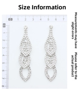 Macro detail of luxurious drop earrings showing 7.5cm length measurement on a ruler
