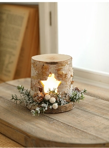 Detail view of a wooden Christmas house lantern with star cutout and warm LED glow