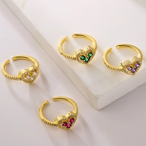 Elegant gold-plated heart-shaped rings with colorful zircon inlay on a stone stand