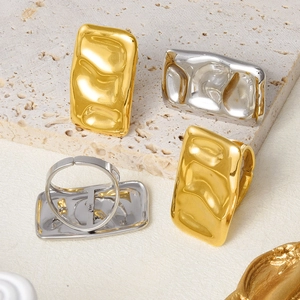 Detailed view of adjustable wavy bar rings in gold and silver finishes on stone base