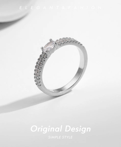 Macro shot of silver ring featuring marquise-cut center stone and paved side diamonds