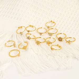 14-piece gold geometric open ring set with stars and pendants on white fabric