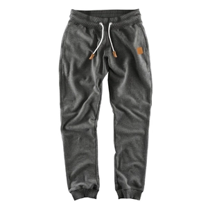 Detail of dark gray joggers featuring a white drawstring and ribbed ankle cuffs