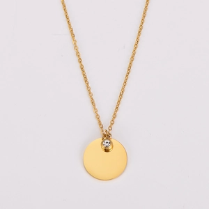Close-up of golden circular pendant necklace with a sparkling cubic zirconia stone