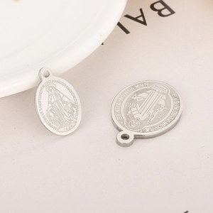Vue détaillée des pendentifs religieux en acier argenté avec Vierge Marie et Saint Benoît