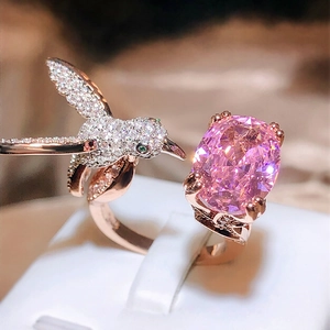 Macro detail of rose gold hummingbird ring with pink gemstone and pavé diamonds