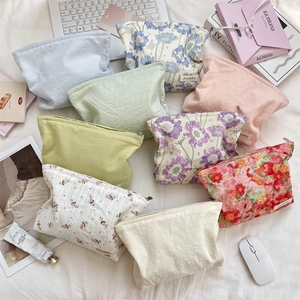 Flat lay of floral and polka dot cotton makeup bags with smooth zipper closures
