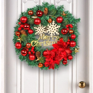 Christmas wreath with red gold ornaments and Merry Christmas sign hanging on white door