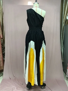 Detail of a one-shoulder color-block maxi dress with black white and yellow wavy panels