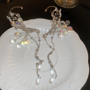 Detailed shot of silver butterfly ear cuffs with sparkling crystals and long tassels