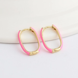 Detailed view of pink enamel and gold-plated oval hoop earrings on a white stand