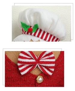 Detail of Christmas gingerbread doll with chef hat, striped bow, and pearl buttons
