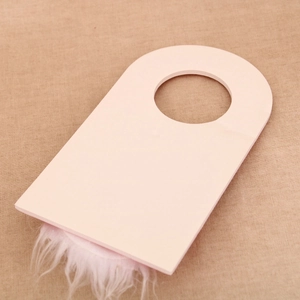Pink Christmas door hanger with white plush fur trim on beige linen background