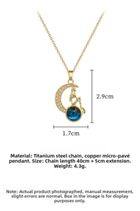 Detail showing gold moon and mermaid necklace with zircon pavé and blue bead charm