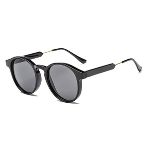Vintage round black and gold sunglasses shown from a 45-degree angle on white background