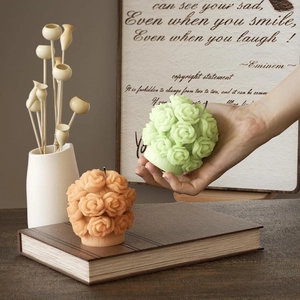 Close-up of rose bouquet candles with detailed floral texture in orange and green tones