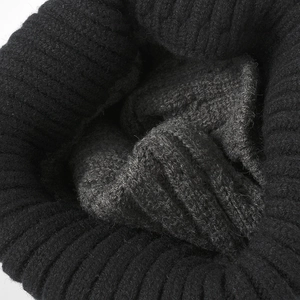 Gros plan d'un bonnet en maille côtelée noir et gris montrant la texture épaisse et chaude