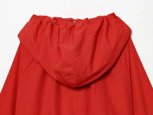 Detail view of the red nylon jacket showing the adjustable hood and seam craftsmanship