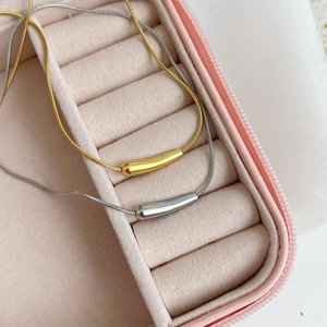 Collane minimaliste in oro e argento presentate in una scatola portagioie in velluto rosa