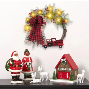 Christmas wreath featuring a red truck, buffalo plaid bow, and warm LED fairy lights