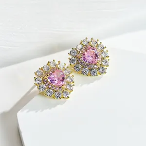 Close-up of heart-shaped pink gemstone earrings with purple and white diamond halo
