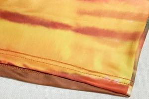 Dettaglio del tessuto tie-dye e della robusta doppia cucitura sulla maglia a maniche lunghe