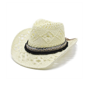Détail du chapeau de paille crème avec pompons noirs, paillettes et tresse ethnique