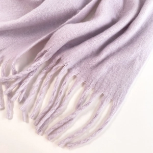 Detailed macro texture of soft lavender mohair scarf with elegant fringed edges