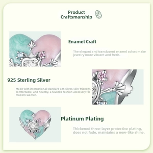 Détail macro du charm coeur en argent S925 avec émail rose et design de couronne