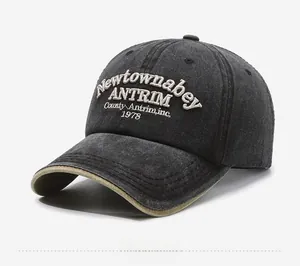 Close-up of white 3D embroidery and vintage washed dark grey fabric on a baseball cap