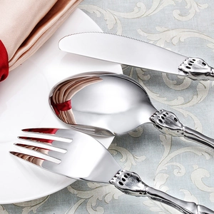 Polished stainless steel cutlery set with skull claw handles on a white plate