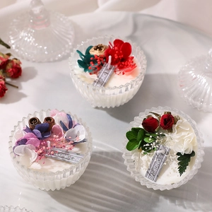 Three scented soy candles in glass jars decorated with dried roses and hydrangea