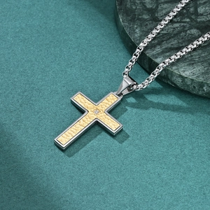 Retro cross pendant necklace with silver chain and gold textured panel on dark marble