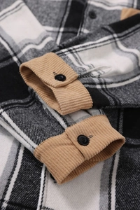 Detail of plaid flannel shirt sleeve with khaki corduroy cuff and black button closure