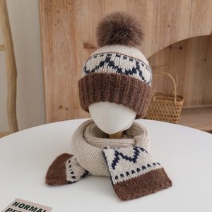 Detail of children's knitted hat and scarf set with geometric patterns and soft pompoms