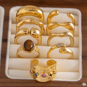 Bagues géométriques dorées et bracelet martelé avec pierres précieuses en boîte à bijoux