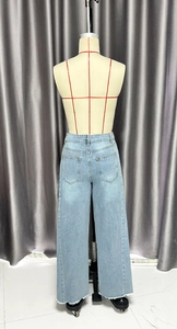Détails du jean large taille haute en denim bleu clair avec ourlet effiloché et poches