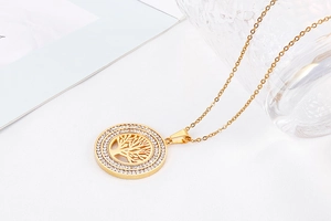 Close-up of golden Tree of Life pendant featuring sparkling clear crystals on outer ring